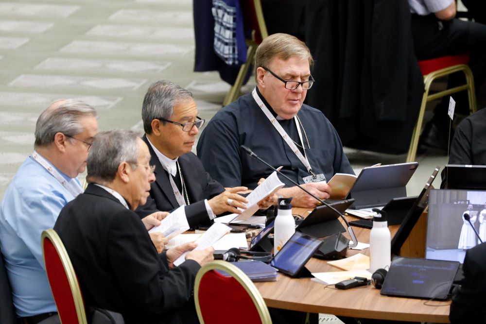 Cardinal Joseph Tobin of Newark, New Jersey, (right) prays before a working session of the Synod of Bishops at the Vatican Oct. 26, 2023. 