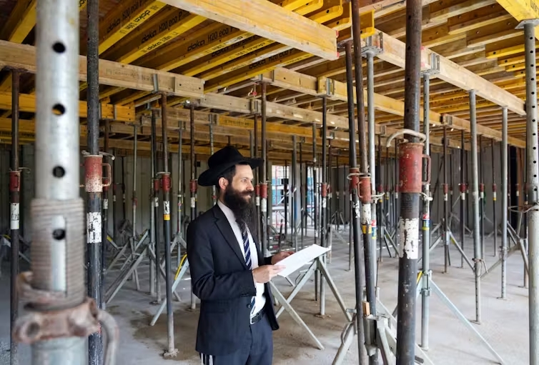 A rabbi in Potsdam, Germany, inspects the construction site of a synagogue. 