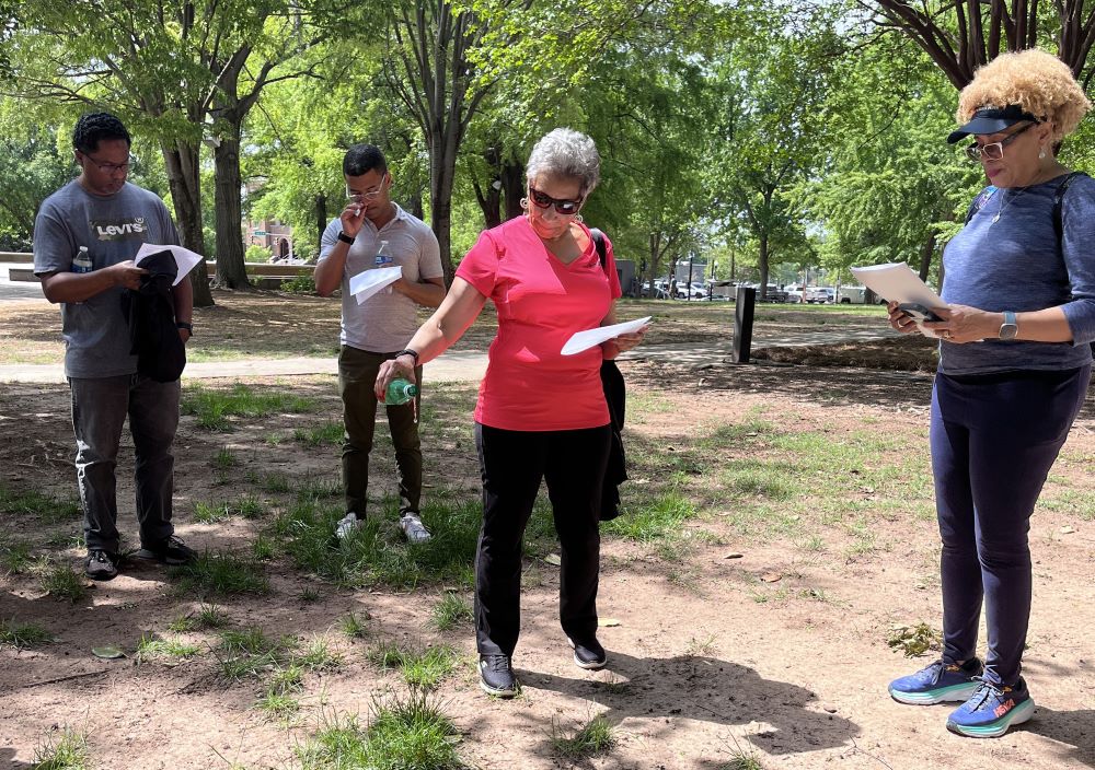 Graduate students in theology and ministry at Catholic Theological Union pour libations on the soil at Kelly Ingram Park in Birmingham, Alabama.