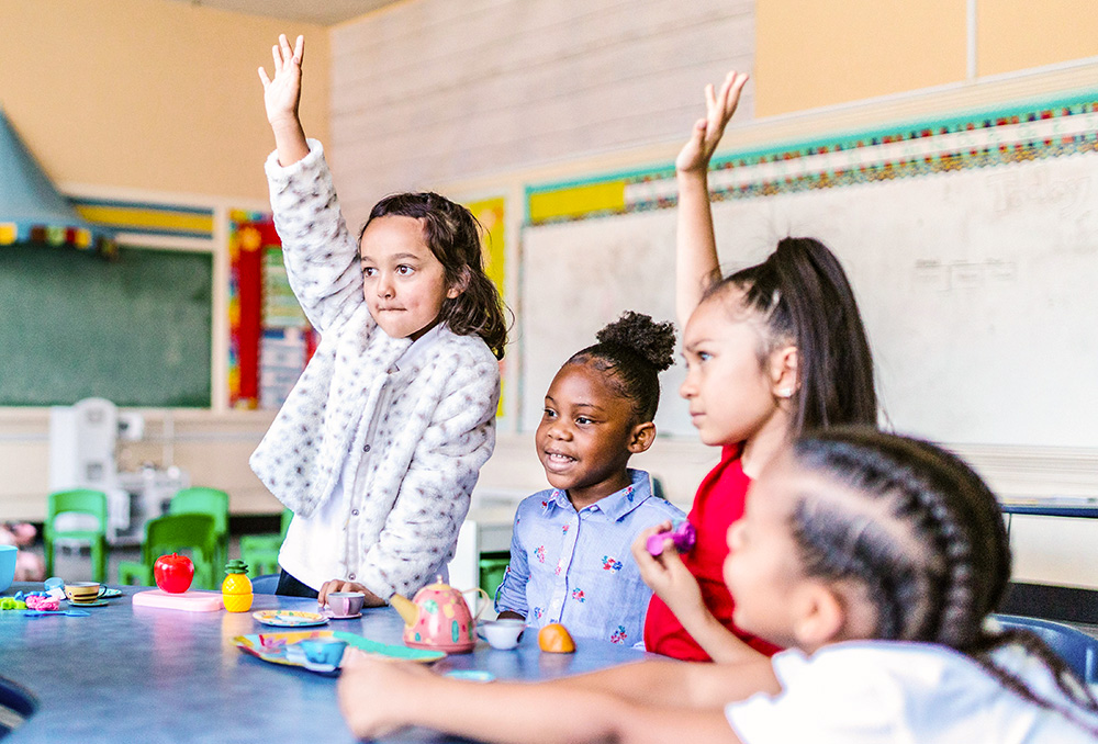 Schoolchildren raise their hands in a classroom. (Pexels/RODNE Stock project)