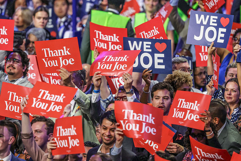 Attendees hold signs as President Joe Biden speaks during Day 1 of the Democratic National Convention in Chicago Aug. 19. (OSV News/Reuters/Mike Blake)