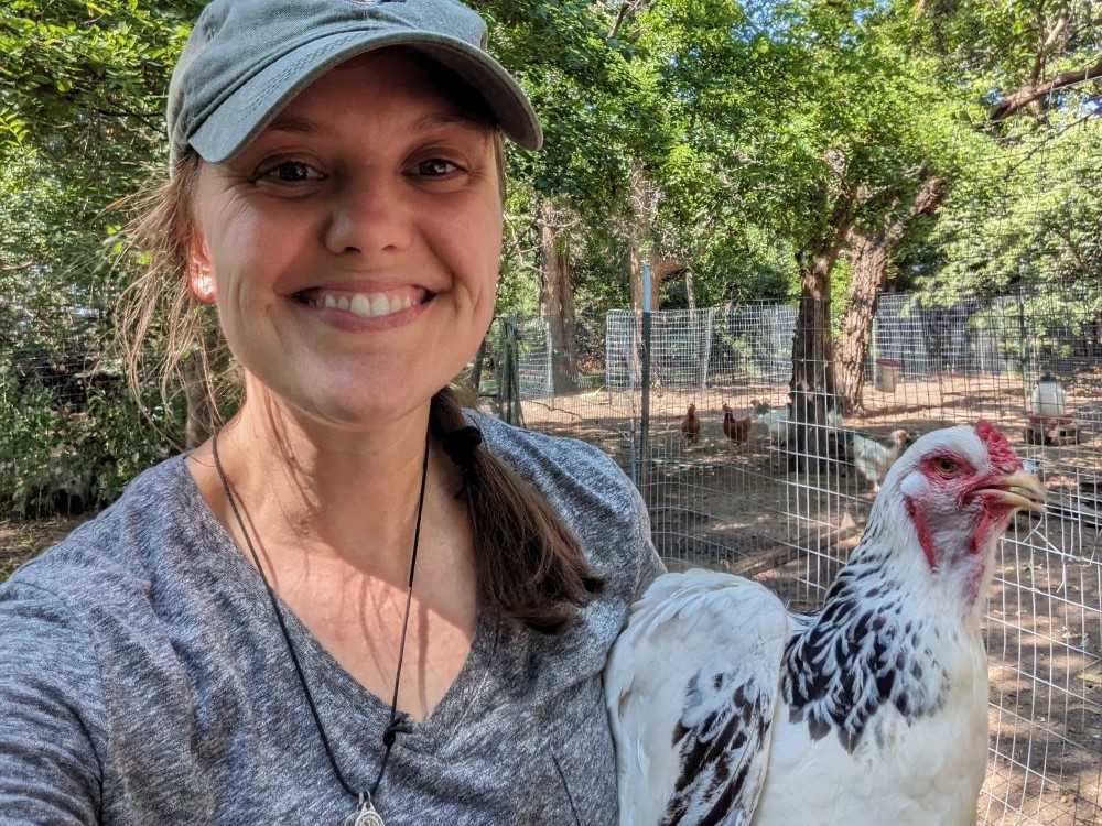 Sr. Terri Schell poses with a chicken. 