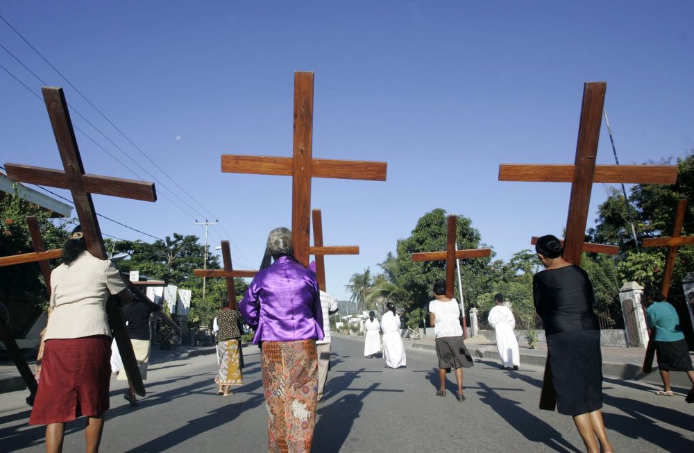 Catholic women carry wooden crosses during a Palm Sunday procession in Dili, East Timor, April 5, 2009.