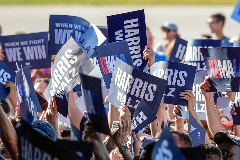 Supporters hold signs before Democratic presidential nominee Vice President Kamala Harris and her running mate Minnesota Gov. Tim Walz arrive for a campaign rally Aug. 7 in Romulus, Michigan. (AP/Carlos Osorio)