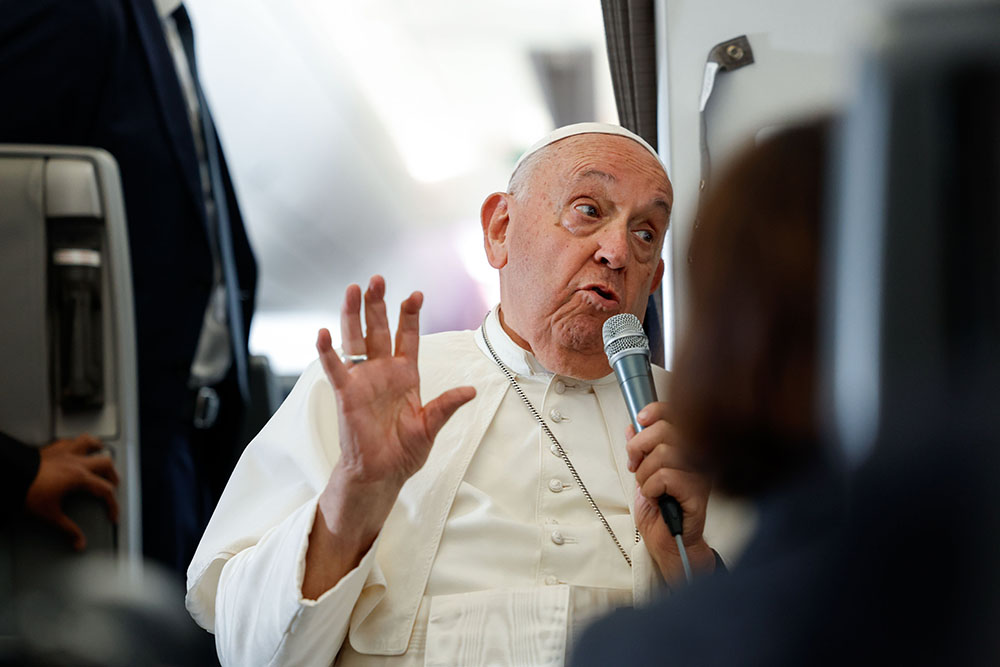 Pope Francis answers a question from a journalist aboard his flight back to Rome Sept. 13, 2024, after visiting Indonesia, Papua New Guinea, Timor-Leste and Singapore. (CNS/Lola Gomez)