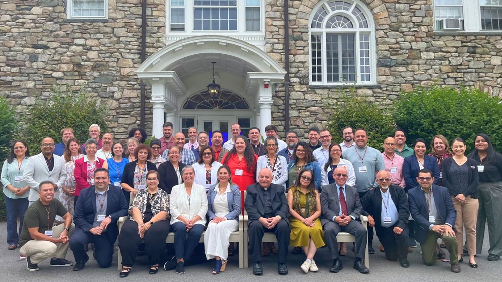 Large group assembled for portrait in front stone building. 