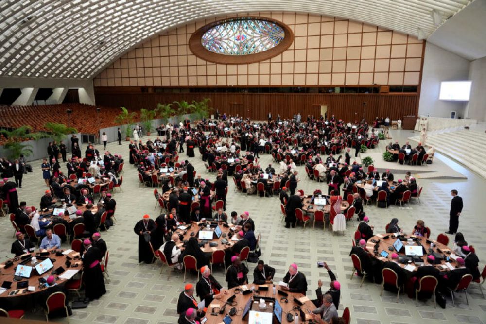 Pope Francis and delegates sit at round tables in the opening session of the 2023 synod on synodality. 