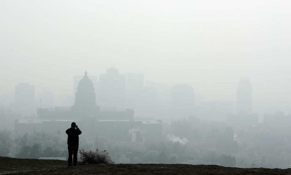 Person takes picture of building shrouded in smog.