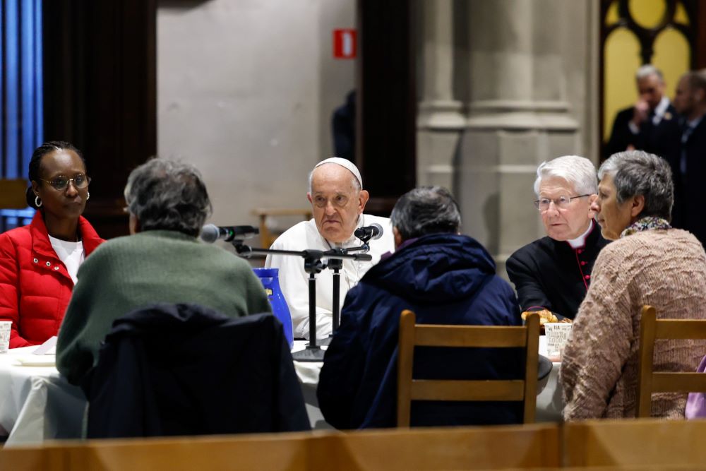 Pope Francis has breakfast with migrants and people who are unhoused in the Church of St. Gilles in Brussels Sept. 28. 