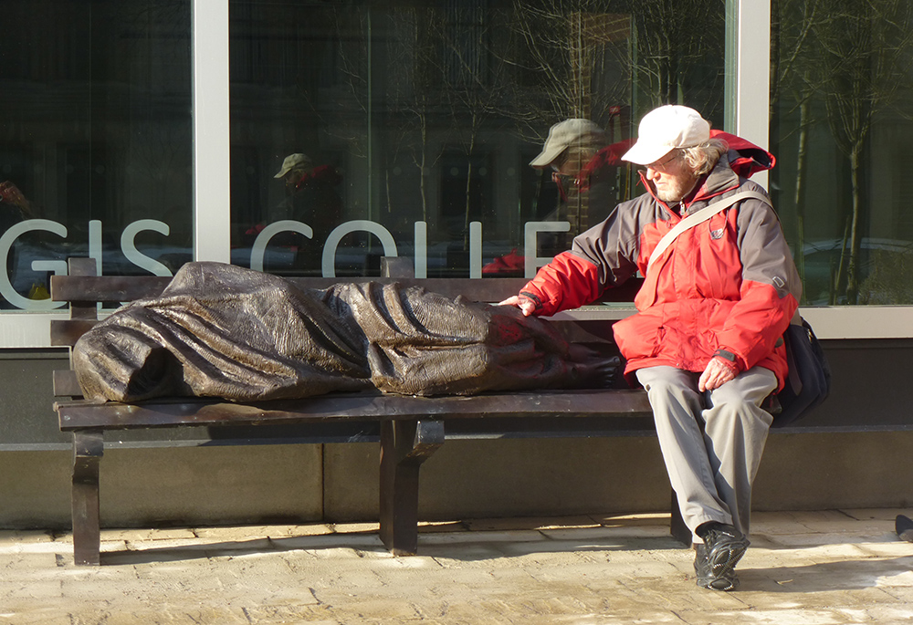 The late Jesuit priest Fr. Peter Livesey, Tim Schmalz's first spiritual adviser, prays with "Homeless Jesus" in Toronto. (Tim Schmalz)