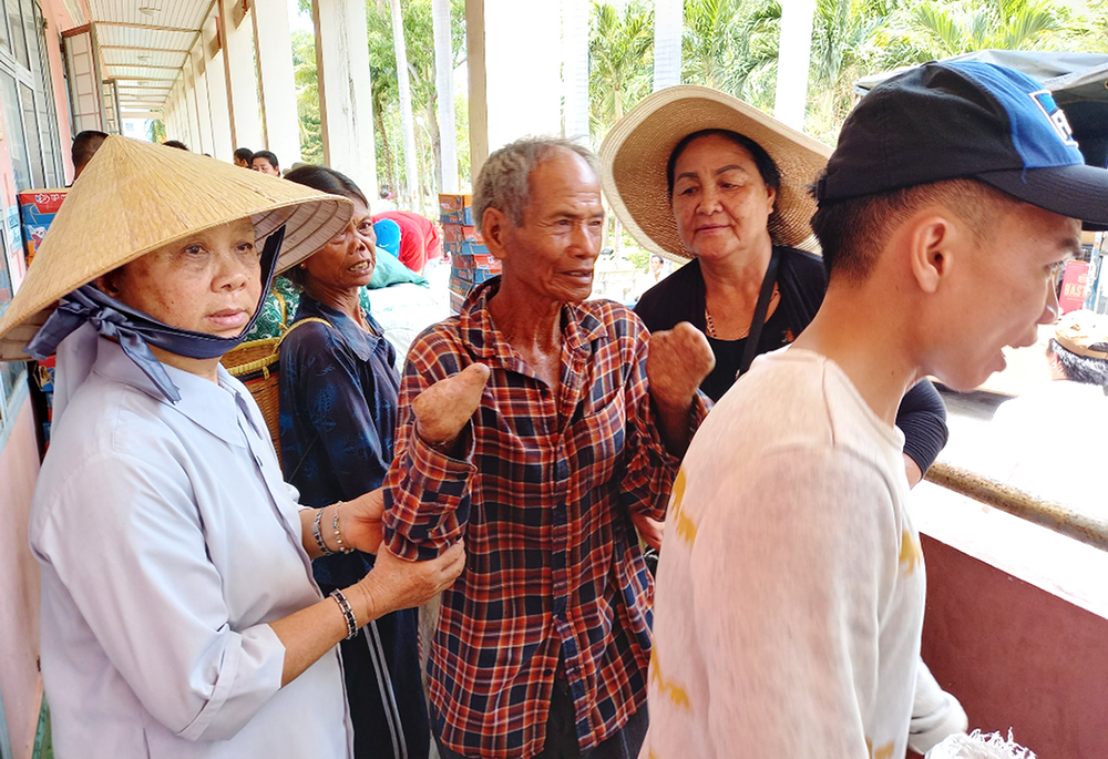 St. Paul de Chartres Sr. Ursuline Pham Thanh Khue, left, receives and offers food to Co Tu ethnic villagers on July 1, at her convent in Quang Nam province, in Vietnam. (GSR photo)