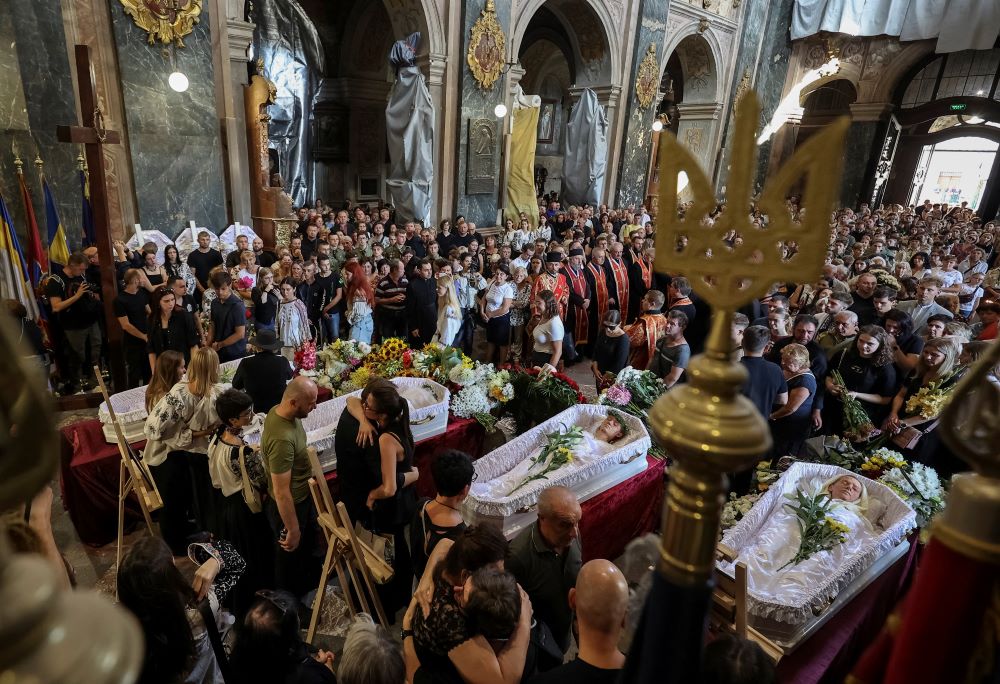 Mourners attend a funeral ceremony in Lviv, Ukraine, Sept. 6 for a woman her three daughters, killed during a Russian airstrike.