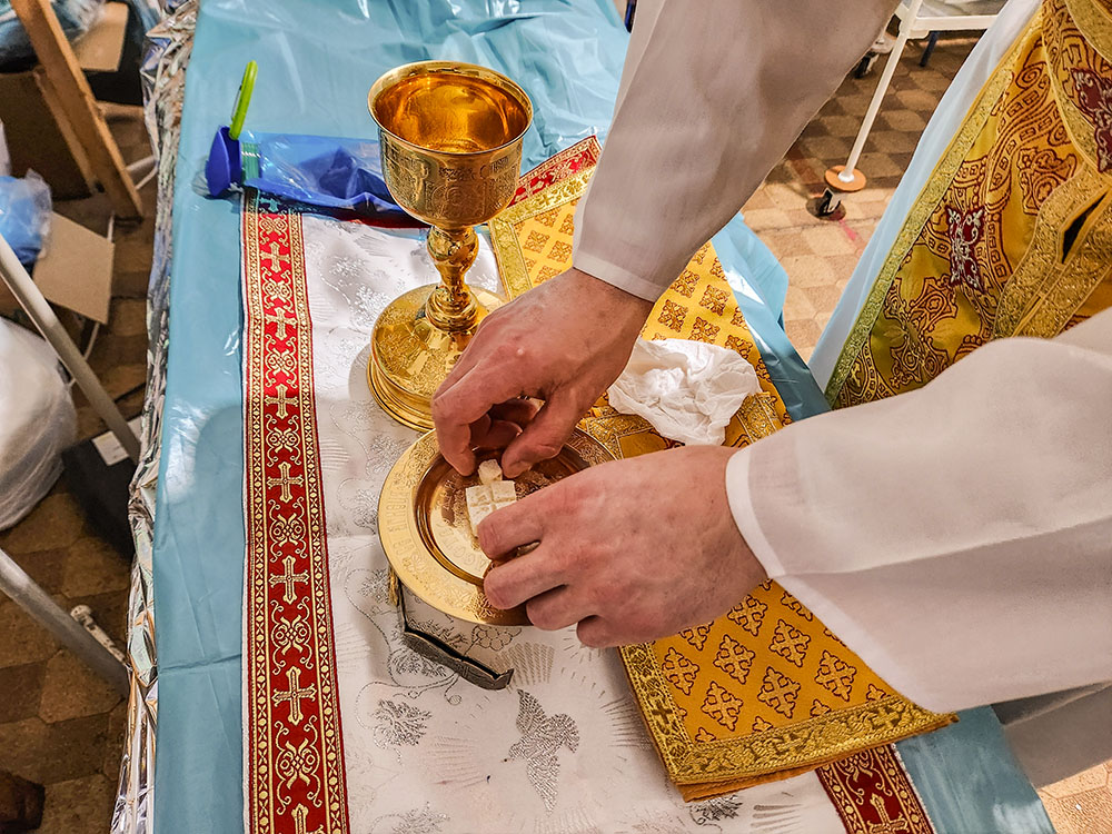 At a triage center in Velykomykhajlivka in southeastern Ukraine, Fr. Aleksandr Bohomoz prepares the sacred vessels needed for Mass. (NCR photo/Chris Herlinger)