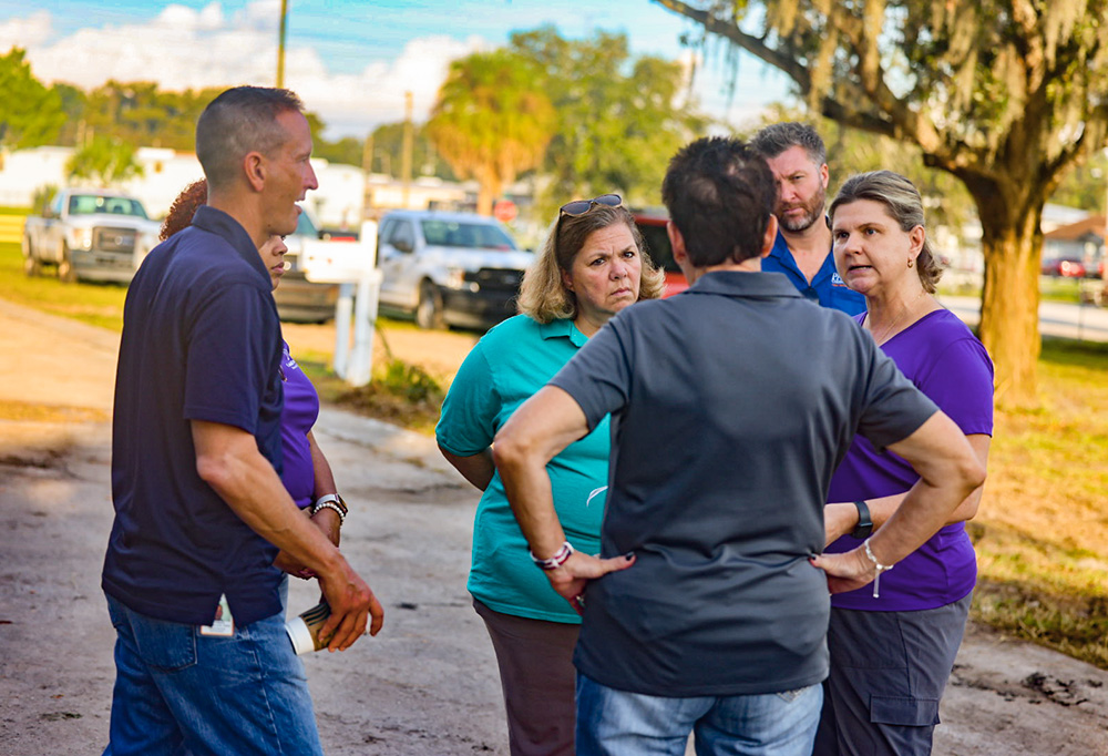 Kim Burgo, center, assesses damage in Florida with staff from Catholic Charities of the St. Petersburg Diocese in the aftermath of Hurricane Helene. (Courtesy of Catholic Charities USA/Jeremy Mines)