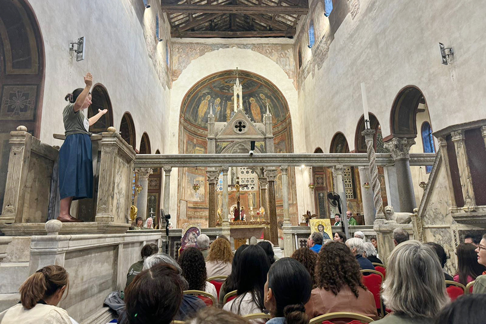 Allison Beyer of South Bend, Indiana, leads a group of pilgrims as they sing a psalm Oct. 6, 2024, at Rome's Basilica of Santa Maria in Cosmedin. Members of the Ecclesial Conference of the Amazon (known as CEAMA) and Discerning Deacons took part in a weeklong pilgrimage to share women's service to the church, to learn about deacons, and to call on the church to approve the diaconate for women as the last part of the Synod on Synodality began the first week of October at the Vatican. (NCR photo/Rhina Guidos)