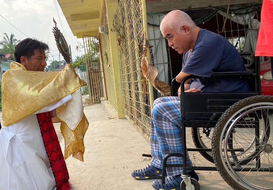 Fr. Marcelo Pérez shows a monstrance to a resident of Simojovel, in Mexico's Chiapas state, June 13, 2020. (OSV News/Courtesy of David Agren)