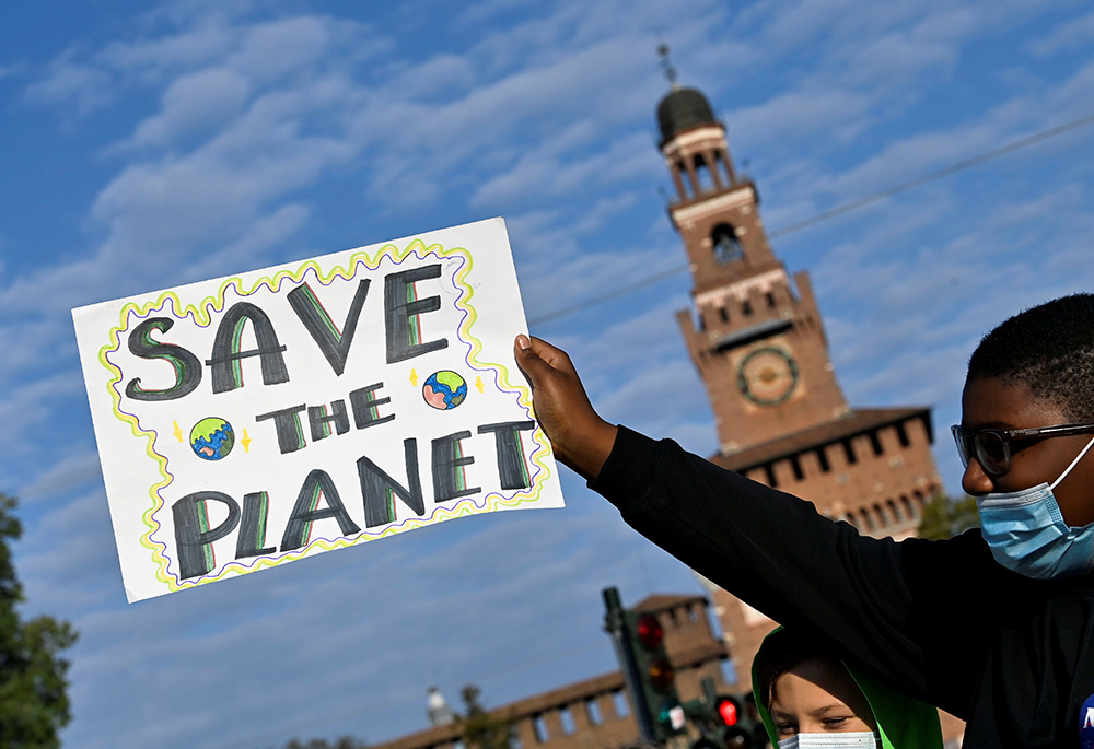 A demonstrator holds up a sign as he attends a Fridays for Future climate strike in Milan Oct. 1, 2021, ahead of the U.N. Climate Change Conference in Glasgow, Scotland. (CNS/Reuters/Flavio Lo Scalzo)