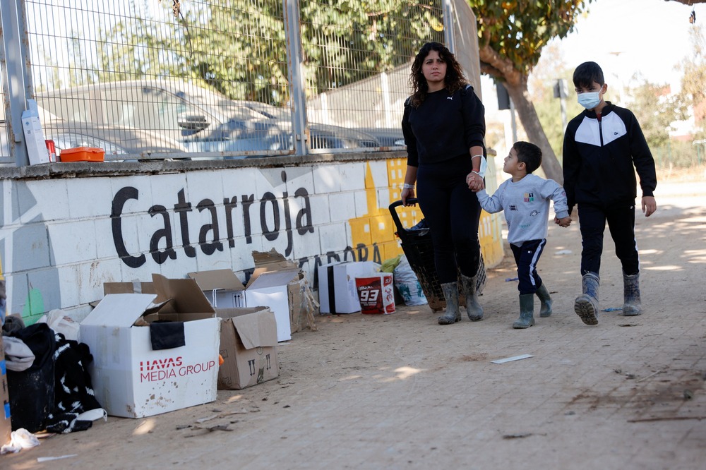 Woman walks with two sons. 