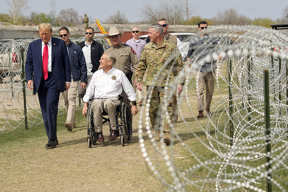 Donald Trump, then a candidate during the Republican presidential primary, talks with Texas Gov. Greg Abbott during a visit to the U.S.-Mexico border Feb. 29 in Eagle Pass, Texas. (AP/Eric Gay)