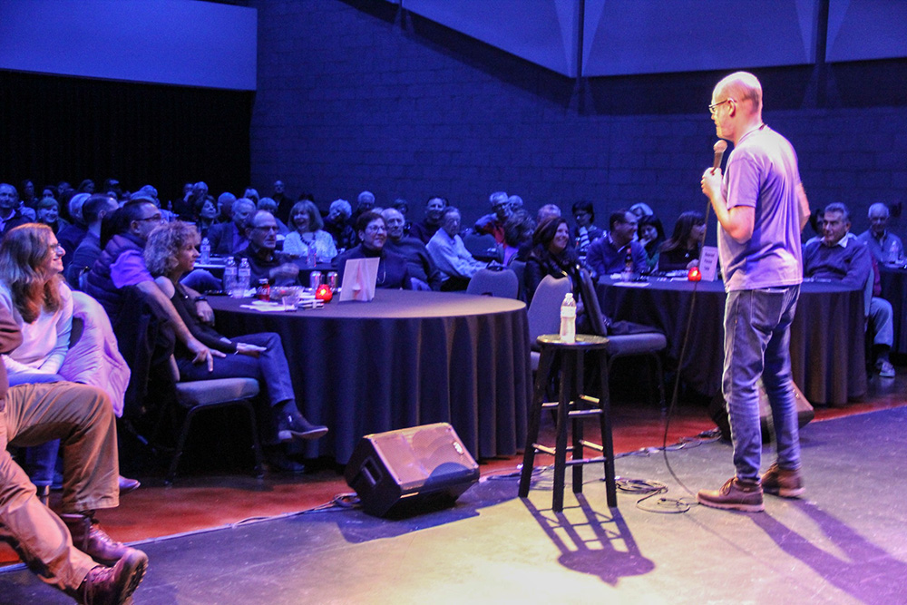 Erik Angel on stage during one of his recent standup comedy shows (Courtesy of Comedy for Peace)