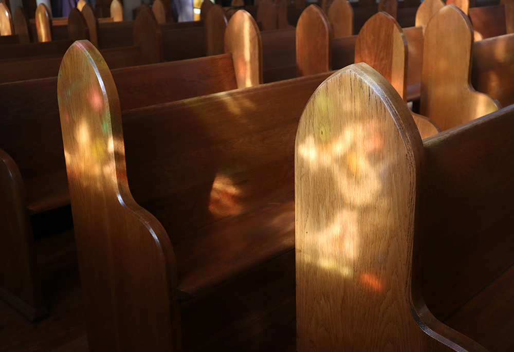 Light shines upon pews in a church interior. (Unsplash/Channel 82)