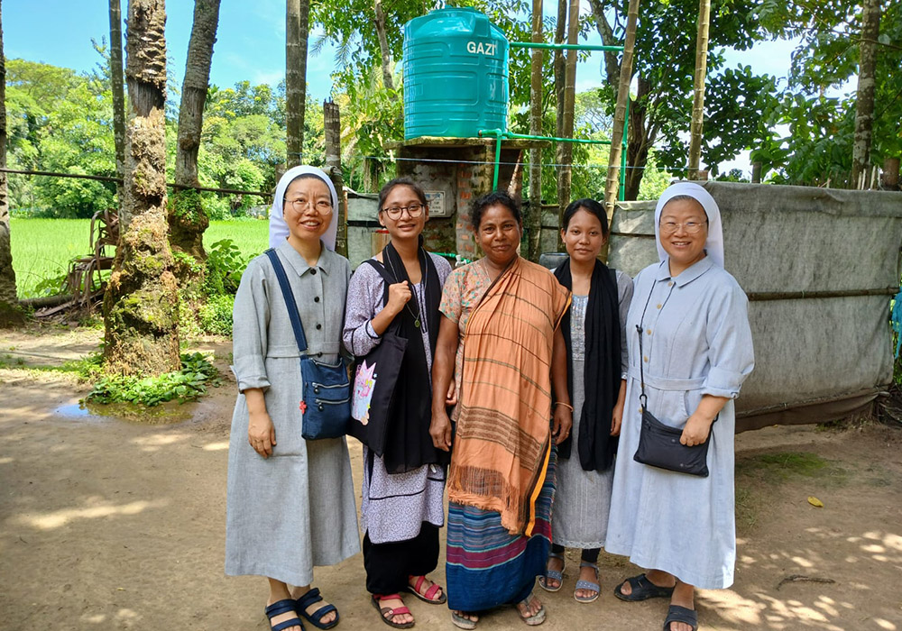 Sister Emma, left, and Sister Agnes, right, are pictured with a family from the Ranikhong Parish who received a tube well from the Sisters of Charity of St. Vincent de Paul, Bangladesh. (Sumon Corraya)