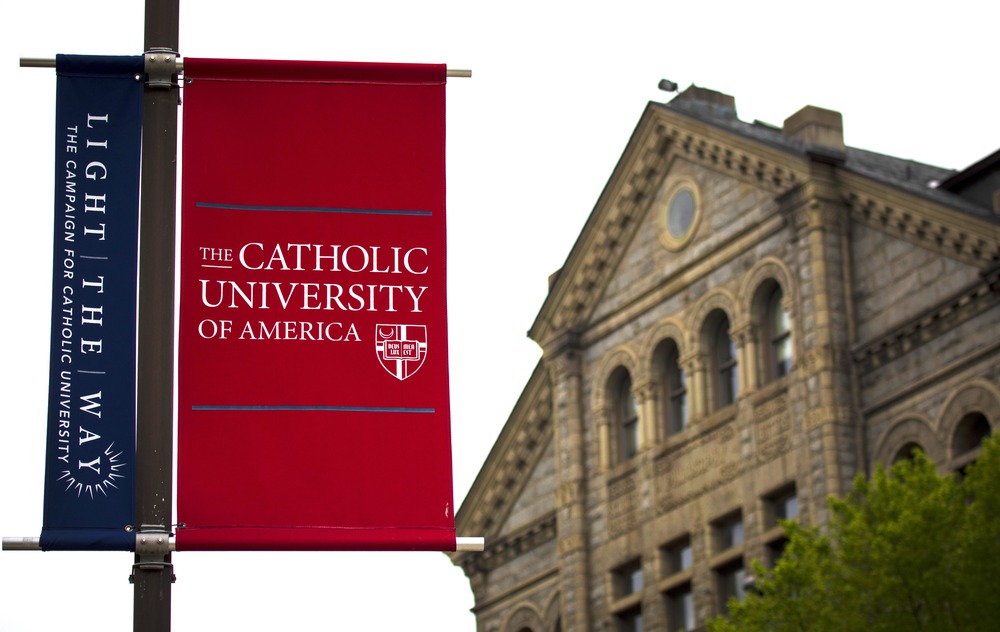 Banner foregrounded, stone building in background.