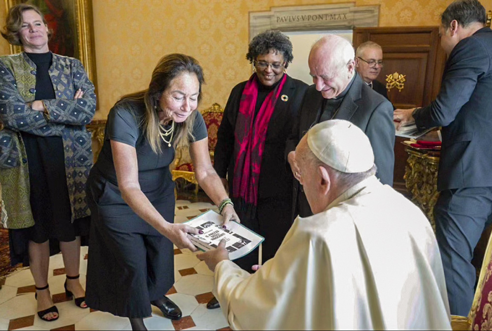 Pope Francis receives a copy of Maria Laurino's book The Price of Children from CBS producer Sabina Castelfranco, with a letter asking for truth and justice signed by a list of Italian adoptees. (Courtesy of Vatican Media)