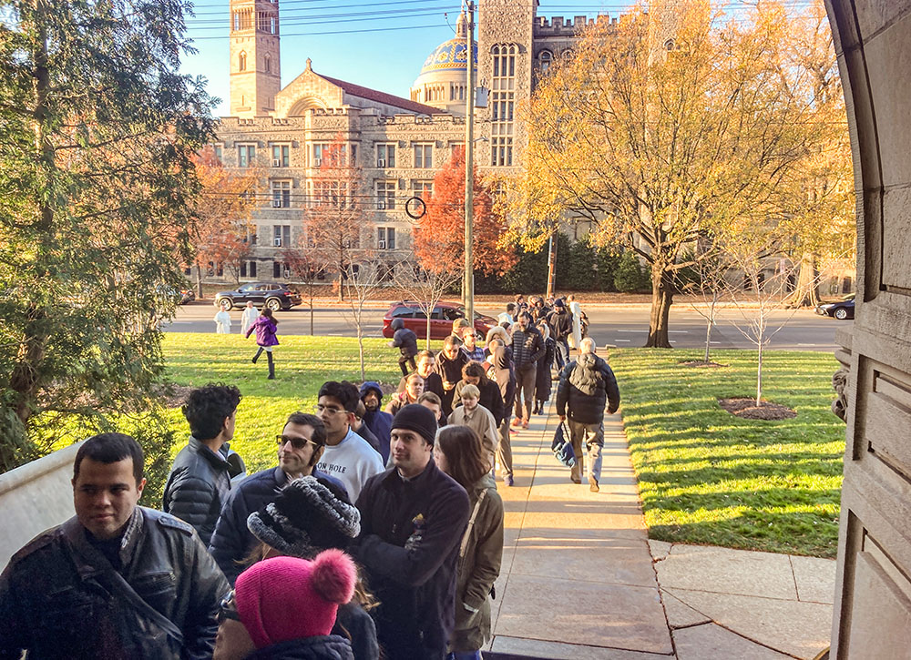 A crowd of people line up outside the Dominican House of Studies in Washington Nov. 30 waiting to venerate what is believed to be the skull of St. Thomas Aquinas. The Basilica of the National Shrine of the Immaculate Conception is in the background. (NCR photo/ Carol Zimmermann)