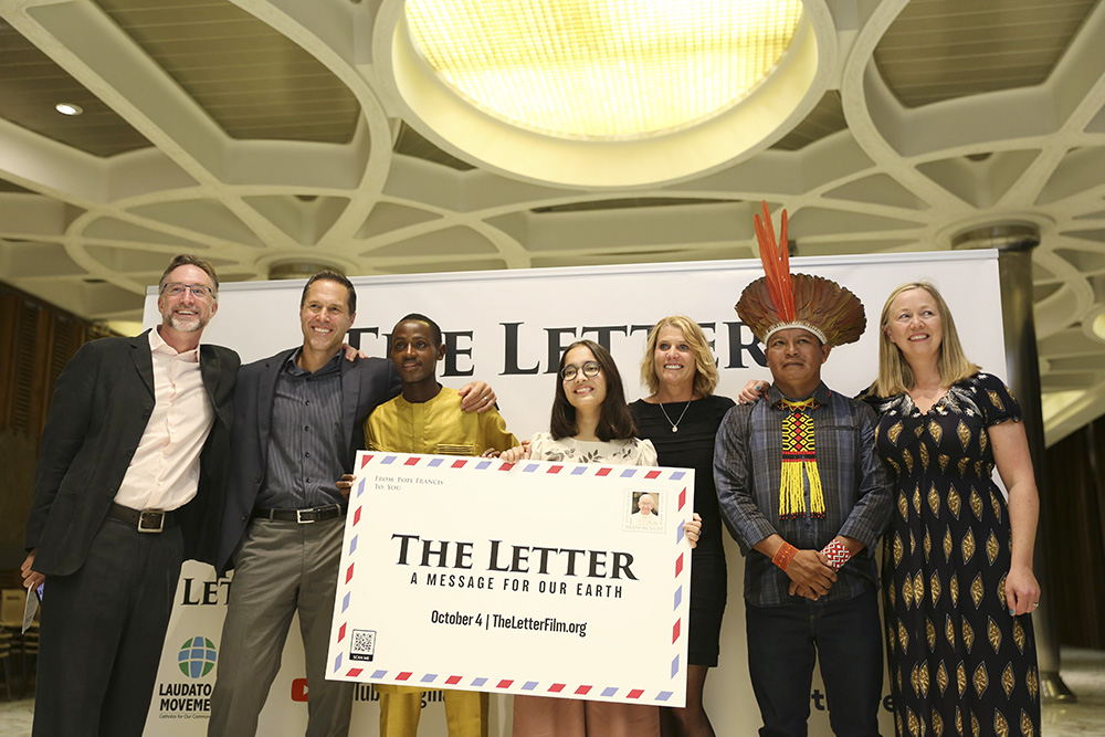 People pose for a photo at the premier of the "The Letter: A Message For Our Earth," a film on Pope Francis' encyclical, "Laudato Si', on Care for Our Common Home," in the Paul VI hall at the Vatican Oct. 4, 2022. Pictured from left are the film's writer and director, Nicolas Brown; U.S. coral reef scientist Greg Asner; Arouna Kandé, a climate refugee from Senegal; Ridhima Pandey, a 13-year-old climate activist from India; U.S. coral reef scientist Robin Martin; Chief Cacique Odair "Dadá" Borari from the Am