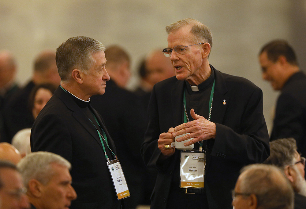 Cardinal Blase Cupich of Chicago, and Archbishop John Wester of Santa Fe, New Mexico, speak during a break at a Nov. 15, 2023, session of the fall general assembly of the U.S. Conference of Catholic Bishops in Baltimore. (OSV News/Bob Roller)