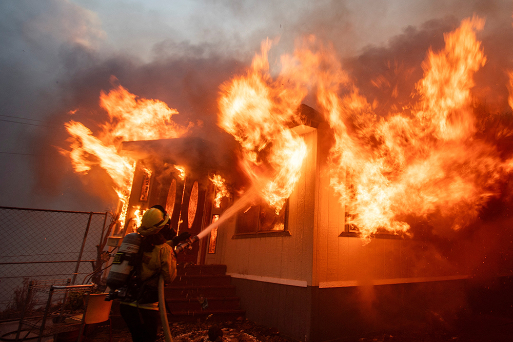 A firefighter battles the Palisades Fire as it burns during a weather-driven windstorm on the west side of Los Angeles Jan. 7, 2025. (OSV News/Reuters/Ringo Chiu)