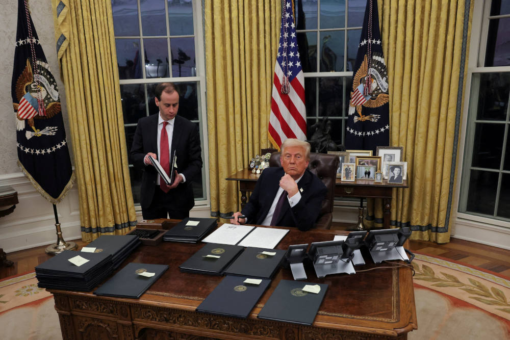 U.S. President Donald Trump signs documents in the Oval Office at the White House on Inauguration Day in Washington Jan. 20, 2025. He signed a series of executive orders including on immigration, birthright citizenship and climate. Trump also signed an executive order granting about 1,500 pardons for those charged in connection with the Jan. 6, 2021, riot at the U.S. Capitol. (OSV News photo/Carlos Barria, Reuters)