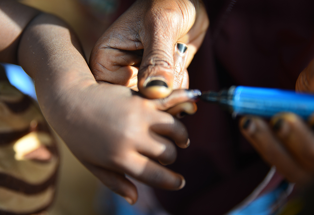 A Nigerian child gets blue ink on her finger to show she has received the polio vaccine. (Patrick Egwu)