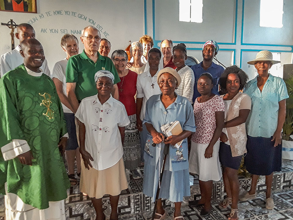 Members of the St. Margaret Mary Catholic Church Haiti mission team, in the back, seen here with Haitian parishioners in a 2018 photo. The Haitian parishioners were from an earlier parish that the team worked with, Our Lady of Perpetual Help. The Florida church now works with another parish, Our Lady of the Assumption. (Courtesy of St. Margaret Mary Church)