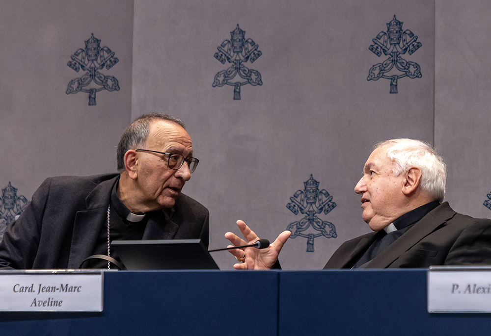 Spanish Cardinal Juan José Omella Omella of Barcelona leans to listen to Cardinal Jean-Marc Aveline of Marseille, France, who were both at a news conference at the Vatican Feb. 20, 2025, to present a peace and dialogue initiative for young people around the Mediterranean Sea. (CNS/Pablo Esparza)