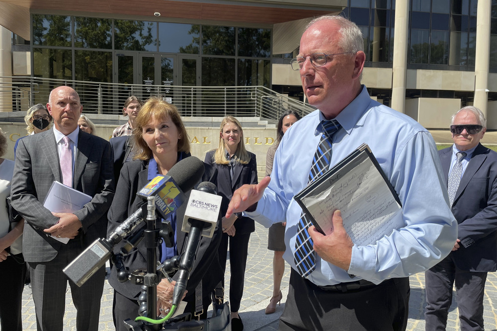 Lorenz standing, holding legal pad and talking into microphone.