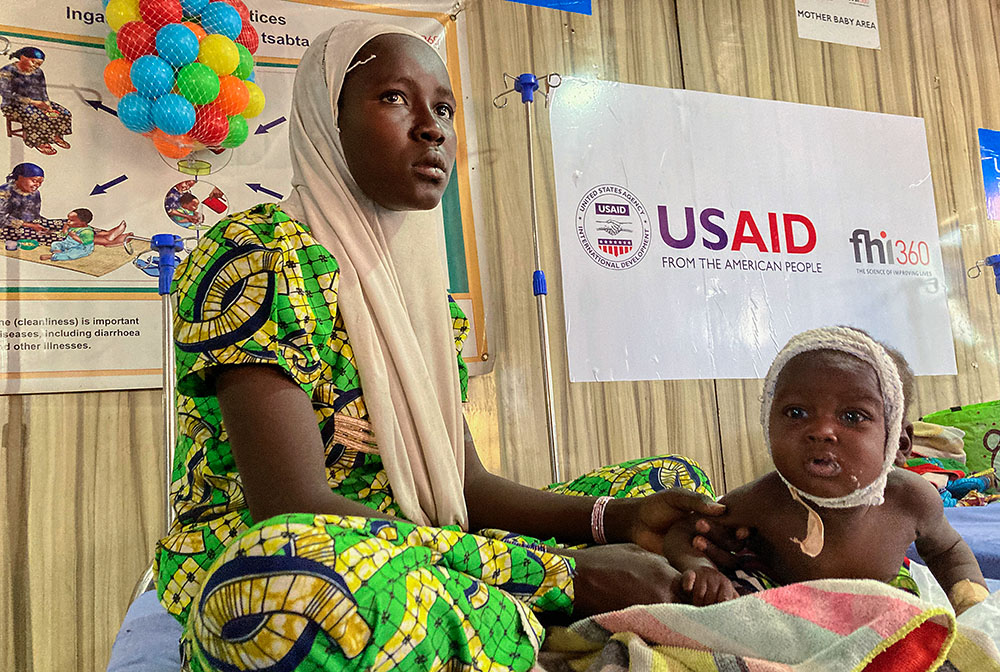 A woman attends to her malnourished child at the United Nations Nutrition Center in Banki, on the outskirts of Maiduguri, Nigeria, May 3, 2022. (AP/Chinedu Asadu)