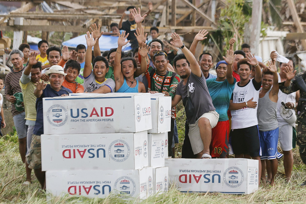 Filipinos are seen in a 2013 photo showing their gratitude and waving to the crew of a U.S. Navy aircraft after receiving aid from U.S. Agency for International Development in the remote village of Guiuan, Philippines, following one of the most powerful typhoons ever recorded. The future of USAID has been called into question amid reports President Donald Trump had agreed to "shut down" the agency, which could have dramatic impacts on the poor and on the groups assisting them. (OSV News/Reuters/Wolfgang Rat