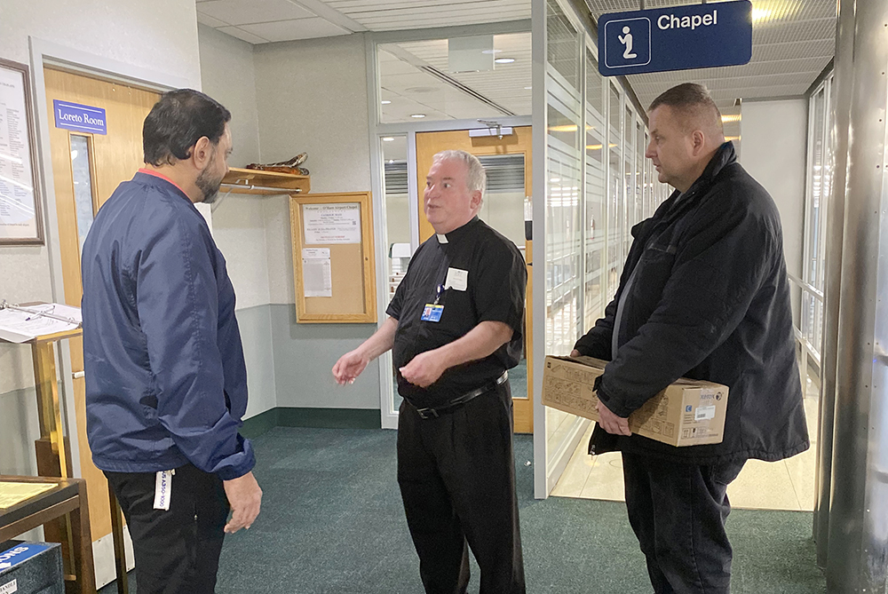 Fr. Michael Zaniolo, center, speaks with people near the chapel at Chicago O'Hare International Airport. (Courtesy photo)