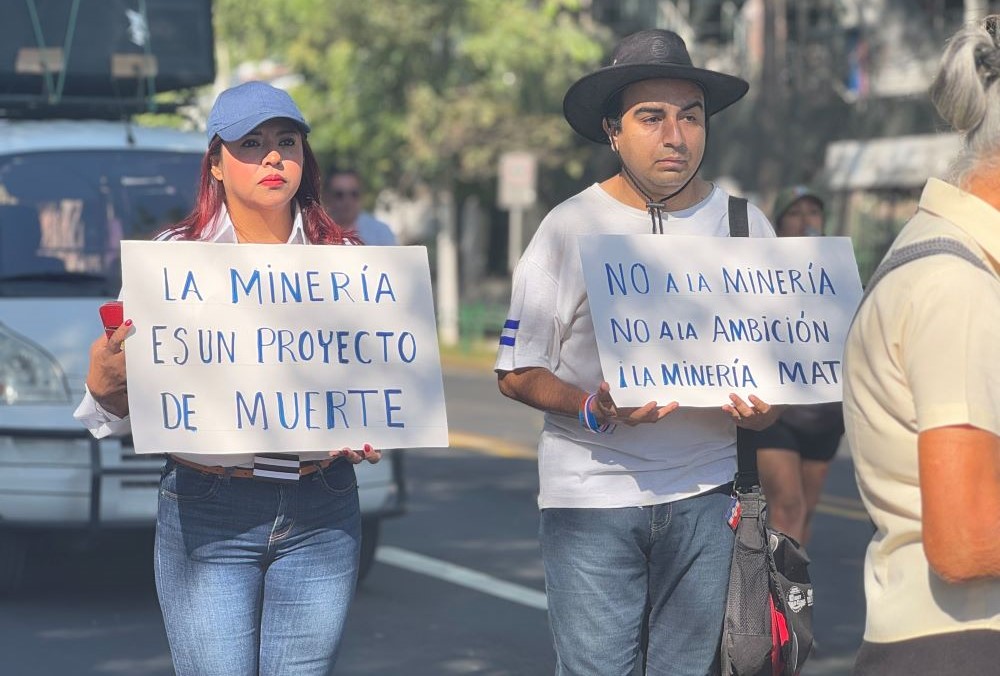 Protesters hold signs against mining.