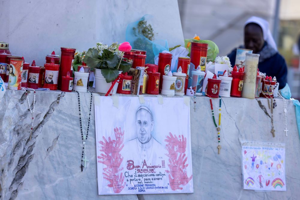 Well-wishers leave devotional items at the base of a statue of St. John Paul II outside Rome's Gemelli Hospital 