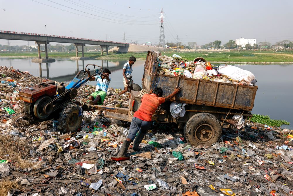 truck of garbage near body of water