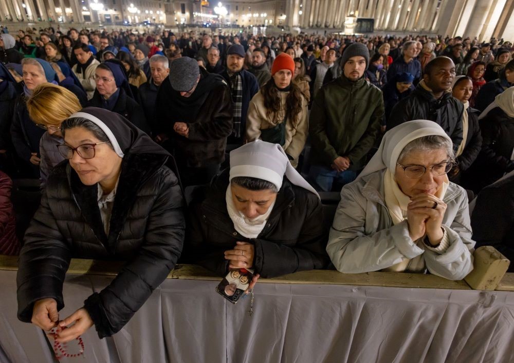 3 nuns pray with large crowd 