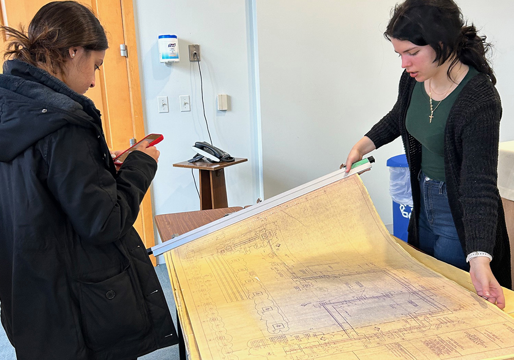 Catholic University students Jacelyn Andrawes and Olivia DiMattio review blueprints of the pastoral center of the Newark Archdiocese during a site visit in October 2024 to conduct an energy audit as part of an architectural course at Catholic University of America. (Patricia Andrasik)