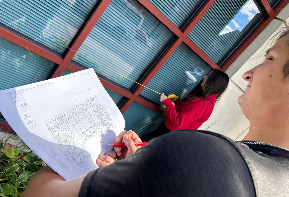 Catholic University of America students take measurements of the pastoral center for the Newark Archdiocese as part of a pilot course providing energy and sustainability recommendations to Catholic dioceses. (Patricia Andrasik)