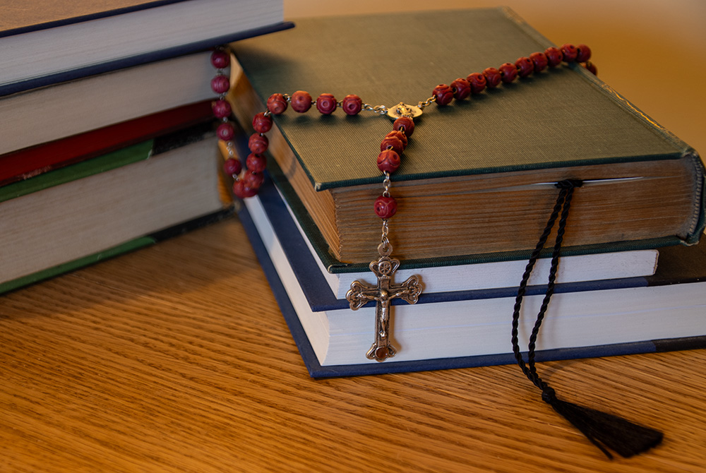 2 stacks of books with a rosary(NCR photo/Teresa Malcolm)