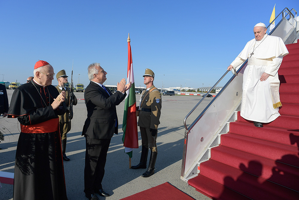 Pope Francis is greeted by Zsolt Semjen, deputy prime minister of Hungary, and Cardinal Peter Erdo of Esztergom-Budapest as he arrives at the international airport in Budapest, Hungary, Sept. 12, 2021. (CNS/Vatican Media)