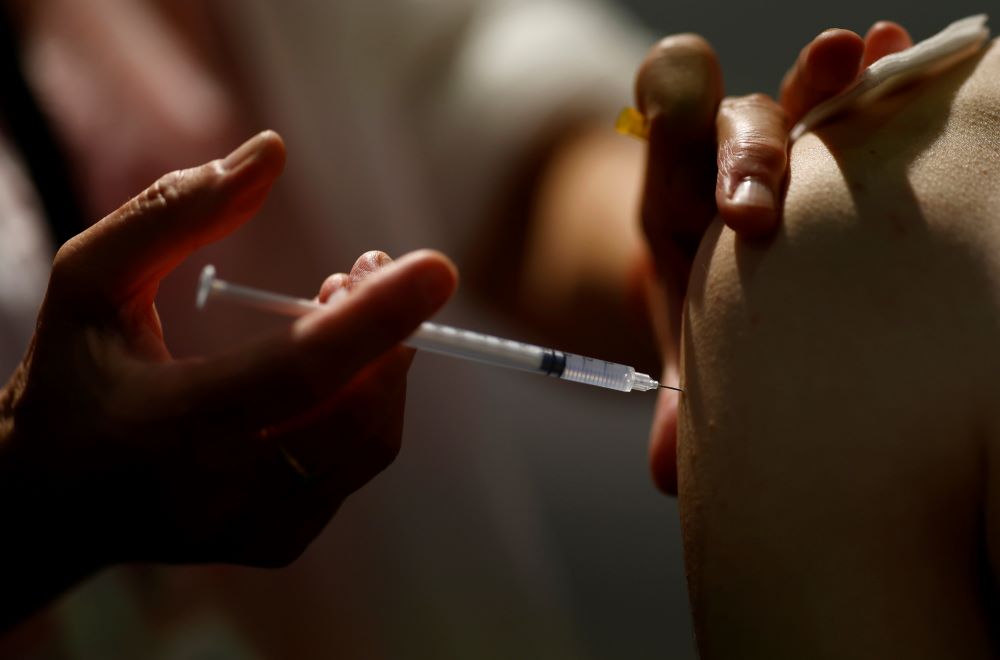 A medical worker administers a dose of the Pfizer BioNTech coronavirus vaccine Sept. 14 at a vaccination center in Nantes, France. (CNS/Reuters/Stephane Mahe)