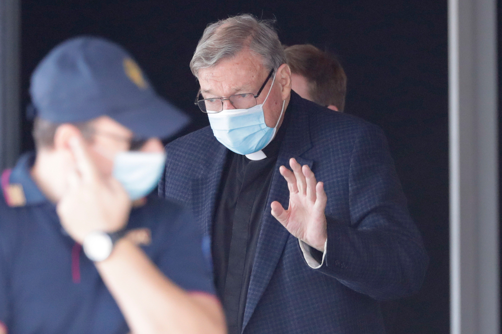 Australian Cardinal George Pell waves as he arrives at Rome's international airport in Fiumicino, Wednesday, Sept. 30, 2020.